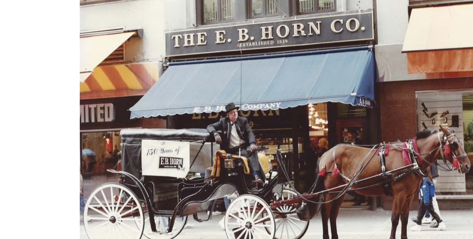Horse and carriage in front of a historic EB Horn bridal jewelry shop in Boston.